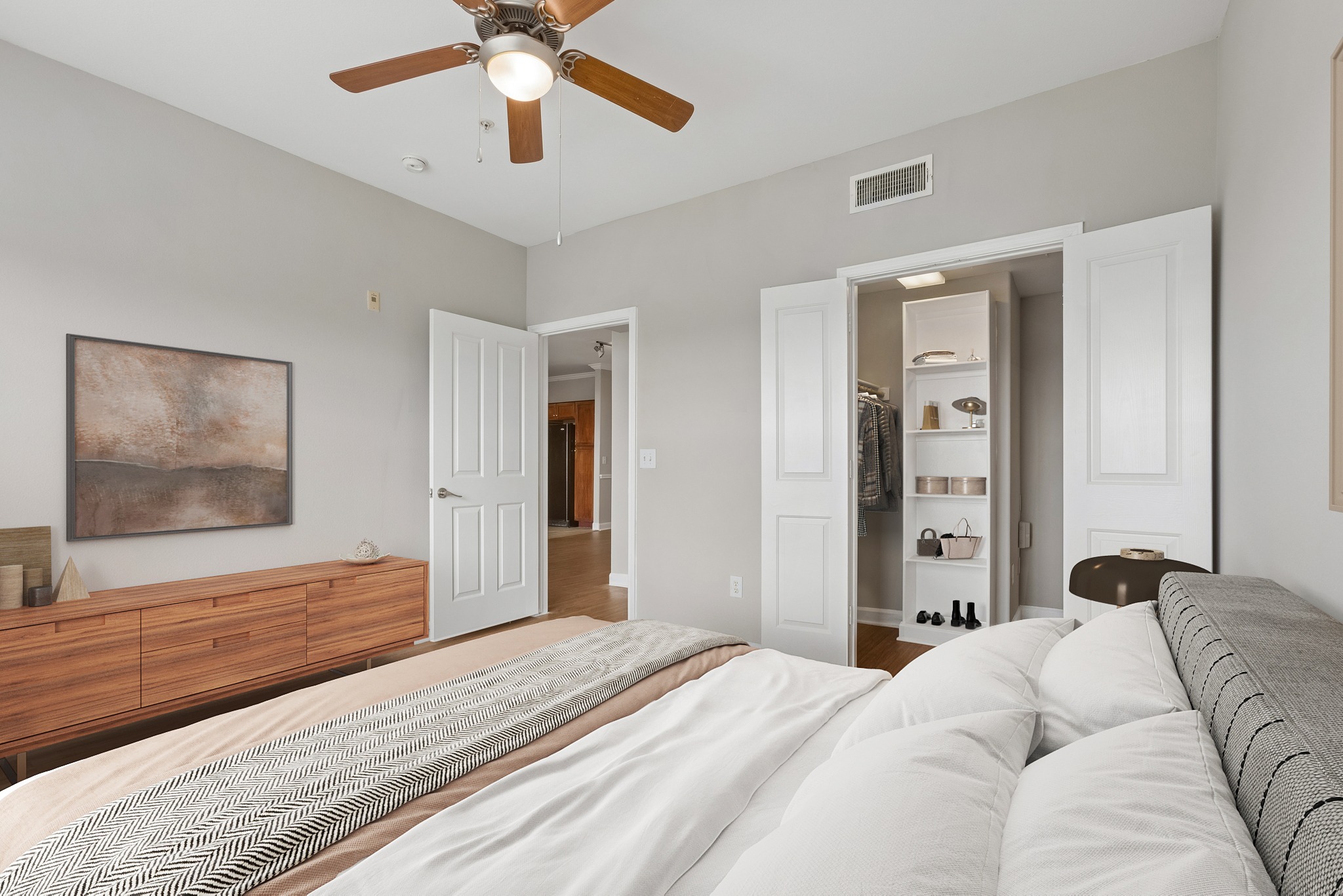 A bedroom with a large bed and a ceiling fan.